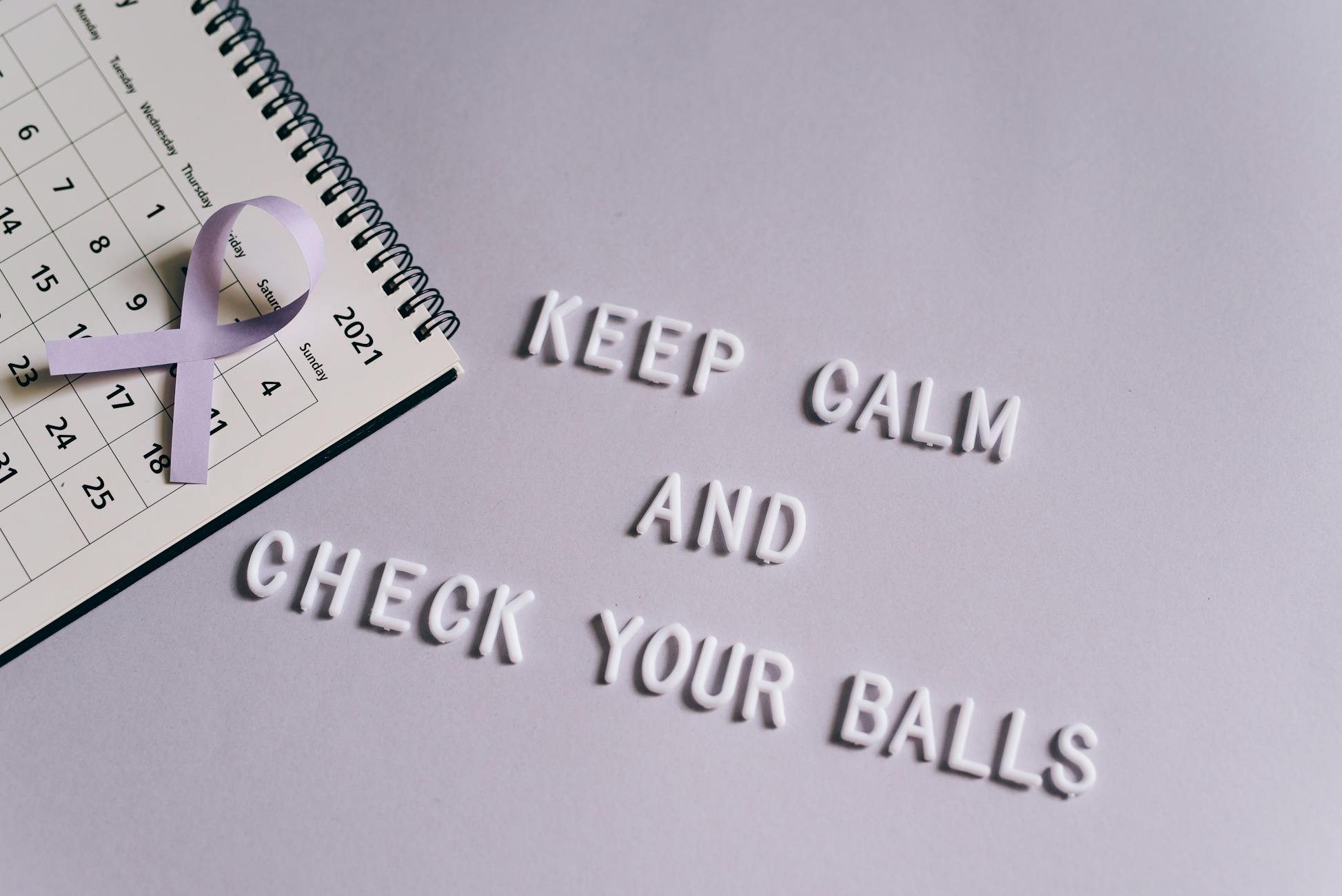 Calendar with quote promoting testicular cancer awareness and a purple ribbon.