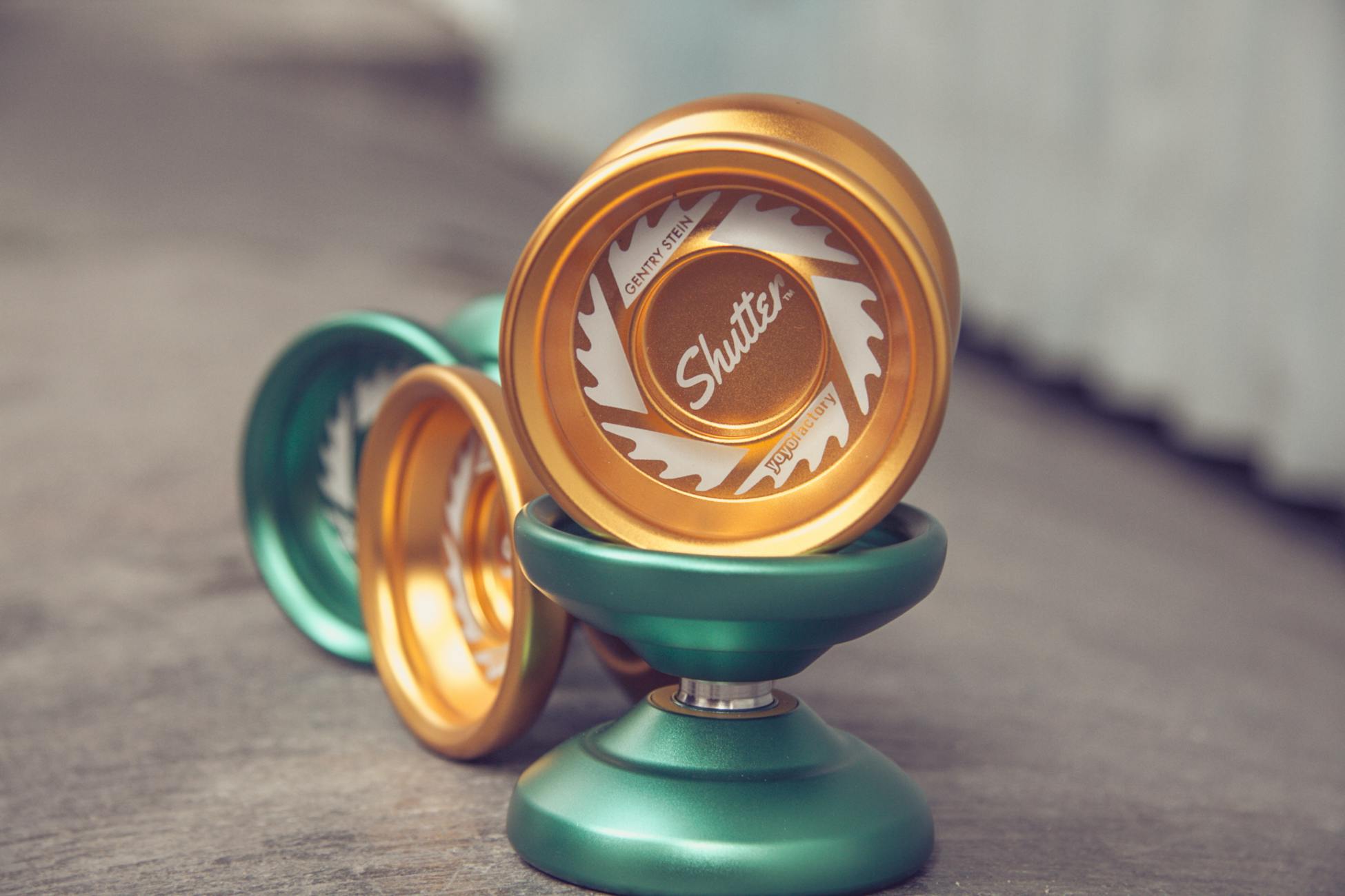 Close-up shot of green and gold yo-yos showcasing detailed design with a blurred background.